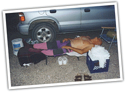 sleeping lightly clad in the shadow of a vehicle